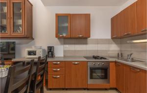a kitchen with wooden cabinets and a stove top oven at Gorgeous Apartment In Njivice With Wifi in Njivice