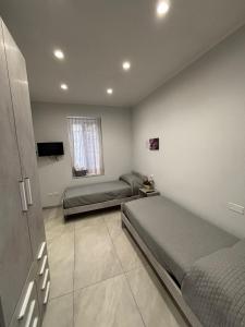 a bedroom with two beds and a tv in it at La casa di Flò in Ercolano