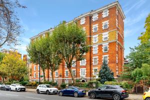 a large brick building with cars parked in front of it at The Bronwen in London