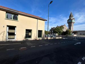 an empty street with a clock tower in the background at L'escapade sensuelle - la love room d'Epernay in Épernay