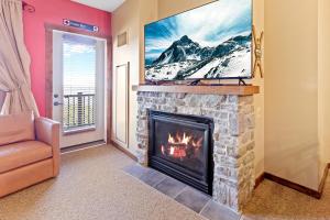 sala de estar con chimenea y TV en la parte superior en Soaring Eagle 303 Next To Slopes Underground Parking Hot Tubs Locker, en Snowshoe 9 fotos más