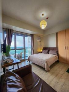 a bedroom with a bed and a large window at The Palladium Iloilo City in Iloilo City