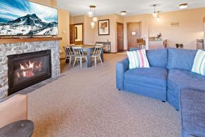 Una sala de estar con un sofá azul y una chimenea. en Soaring Eagle 303 Next To Slopes Underground Parking Hot Tubs Locker, en Snowshoe