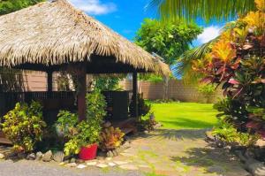 una capanna con tetto in erba e un cortile di Fare D'hôtes Tutehau a Papeete
