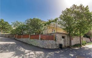 a house with a stone wall and a fence at Lovely Apartment In Sveti Juraj in Sveti Juraj