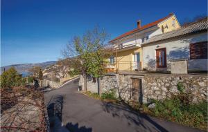 a house with a stone wall next to a street at Lovely Apartment In Sveti Juraj in Sveti Juraj