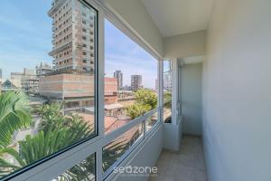 a balcony with windows and a view of a city at Apto Charmoso a 550m da Praia Perequê - RNE0301 in Perequê