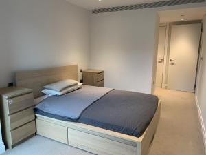 a bedroom with a large bed with a wooden headboard at Stylish 2 Bed Flats Near US Embassy in London