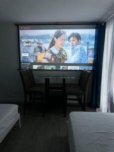 Televiisor ja/või meelelahutuskeskus majutusasutuses Studio w projector Wifi Netflix and pool access in ADB Tower Ortigas CBD