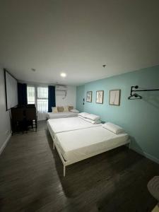 Studio w projector Wifi Netflix and pool access in ADB Tower Ortigas CBD في مانيلا: غرفة نوم كبيرة بسريرين وبيانو