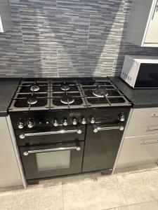 a stove top oven in a kitchen at Cosy rooms near Gatwick Airport in Ifield