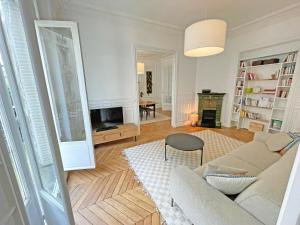 ein Wohnzimmer mit Couch und Kamin in der Unterkunft Magnifique T4 proche Proche Arc de Triomphe et Champs Elysées in Paris