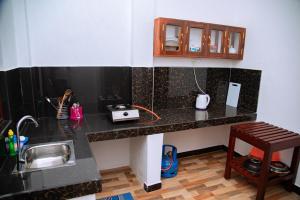 a kitchen with a counter with a sink and a stool at Shadow Surf Bay in Tangalle +130 photos