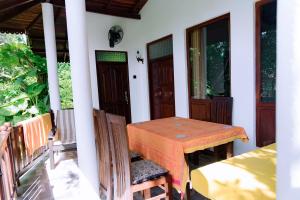 a table and chairs on the porch of a house at Shadow Surf Bay in Tangalle