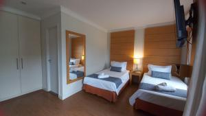 圣保罗Flat Hotel Aeroporto Congonhas com piscina (110H)的有两张床和一面镜子的酒店房间
