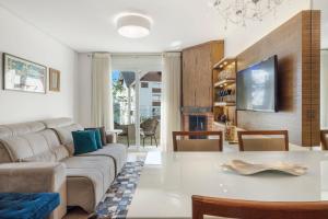 a living room with a couch and a table at Loft central para família by Achei Gramado in Gramado