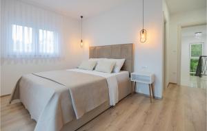 a white bedroom with a large bed and a wooden floor at Cozy Home In Grubine With Wifi in Grubine