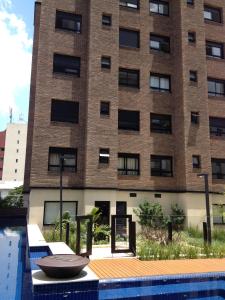 un edificio con piscina frente a un edificio en Estúdio Vila Madalena en São Paulo