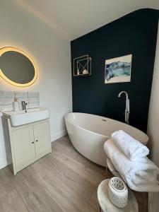a bathroom with a large white tub and a sink at House in the heart of Pembroke in Pembroke +43 photos