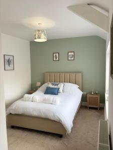 a bedroom with a large white bed with blue pillows at House in the heart of Pembroke in Pembroke