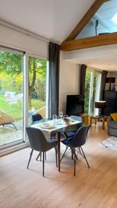 comedor con mesa y sillas en la sala de estar en Duplex Le Colombier - Beautiful Charming Home, en Magny-le-Hongre
