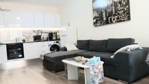 a living room with a couch and a table at Juls 2 bed flat- Bulgaria mall FREE parking in Sofia