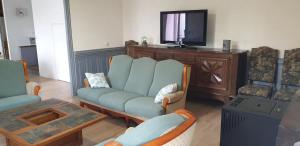 a living room with a blue couch and a tv at Maison de maître in Bressuire
