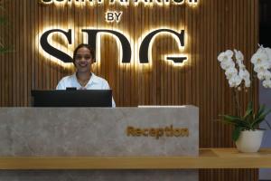 a woman standing behind a counter with a laptop at Sunny Aparts 2 in Canggu +95 photos