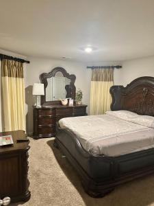 a bedroom with a bed and a dresser and a mirror at Exquisite 5 Bedroom Near Airport in Ellenwood