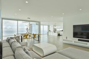 ein Wohnzimmer mit einem großen Sofa und einem Tisch in der Unterkunft Villa Noelia Ocean View in Prazeres