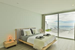 ein Schlafzimmer mit einem Bett mit Blick auf das Meer in der Unterkunft Villa Noelia Ocean View in Prazeres + 38 Fotos
