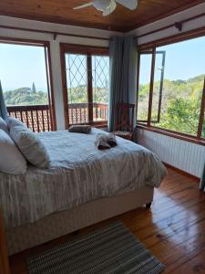 a bedroom with a bed and a balcony with windows at Townhouse at Eagles Nest, Southport, KZN south coast in Port Shepstone