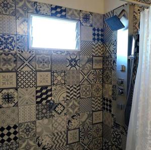 ein Bad mit einer gefliesten Wand und einem Fenster in der Unterkunft Aguarà del Sol-Aguarà Guazù in Valle Hermoso + 9 Fotos