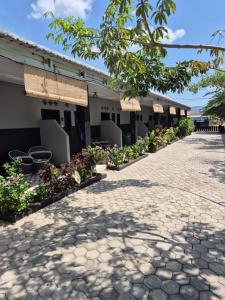 a walkway in front of a building with flowers at Juliana HomeStay in Dorobanggo
