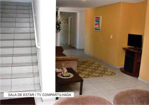 a living room with a couch and a table at Villa Tata Suítes Ltda in Curitiba