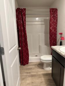 a bathroom with a toilet and a shower curtain at Exquisite 5 Bedroom Near Airport in Ellenwood +31 photos