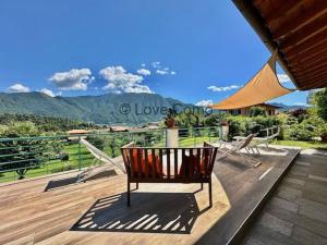 a bench on a deck with a view of a mountain at Villa 3 Olivi - Lenno by LoveComo in Lenno