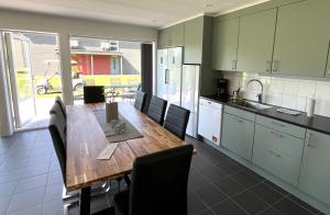 a kitchen with a wooden table and chairs in a kitchen at Saxnäs Ferieboende Freja in Färjestaden