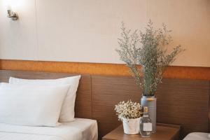 a hotel room with a bed and a table with flowers at Clef Hotel - SHA Plus in Bangna