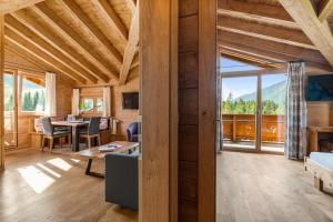 Una sala de estar con una mesa y una gran ventana. en Schickster Mountain Lodge, en Unterweidach
