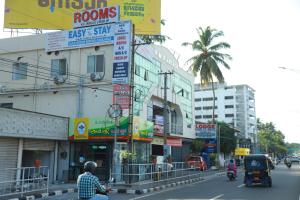 un hombre en una motocicleta por una concurrida calle de la ciudad en Easy Stay Eranhipalam, en Kozhikode