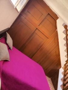a bed with a wooden door in a room at Casa Madrigal in Guanajuato