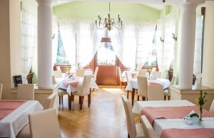 a restaurant with tables and chairs and a chandelier at U Pana Cogito in Kraków