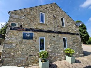 a stone building with two potted plants in front of it at The Granary at High Brooms Farm in Consett