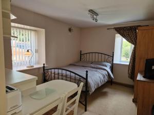 a bedroom with a bed and a table and a window at The Granary at High Brooms Farm in Consett