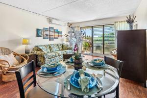 una sala da pranzo con tavolo e sedie in vetro di Kihei Akahi D205 a Wailea