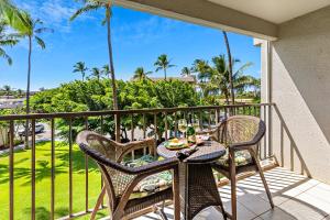 un tavolo e sedie su un balcone con palme di Kihei Akahi D205 a Wailea
