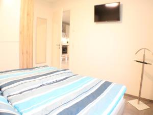 Cama en habitación con TV en la pared en Sielhuus 9, en Fedderwardersiel