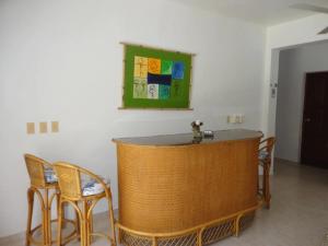 a bar in a room with chairs and a table at Hotel Angel Gabriel in Boca Chica