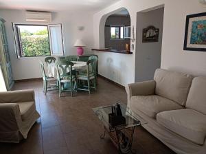 un salon avec un canapé, une table et des chaises dans l'établissement Villa Lombardi, à Alaior